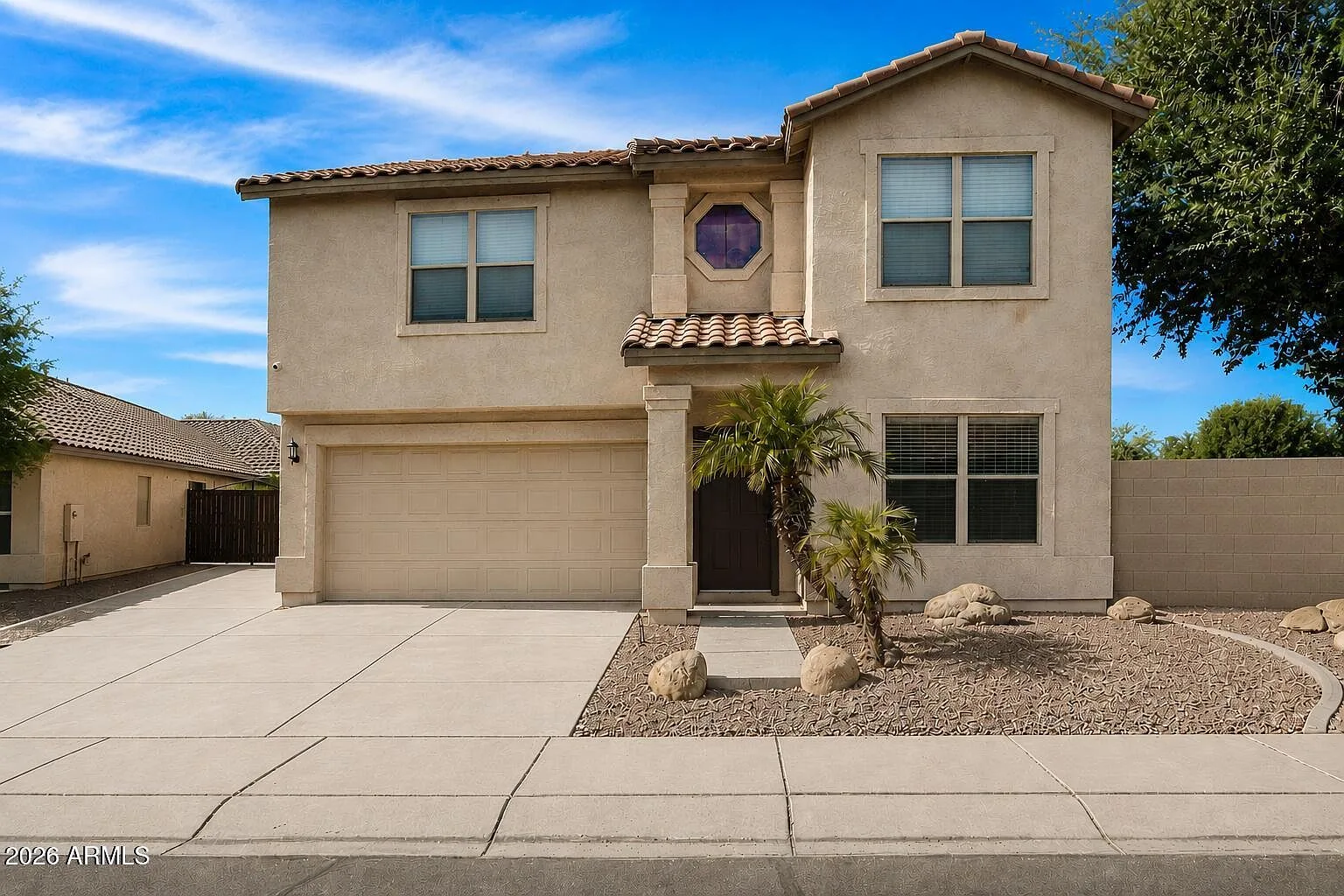 Sunlit Arizona home with sandstone stucco, terracotta tile roof, and desert landscaping in Phoenix
