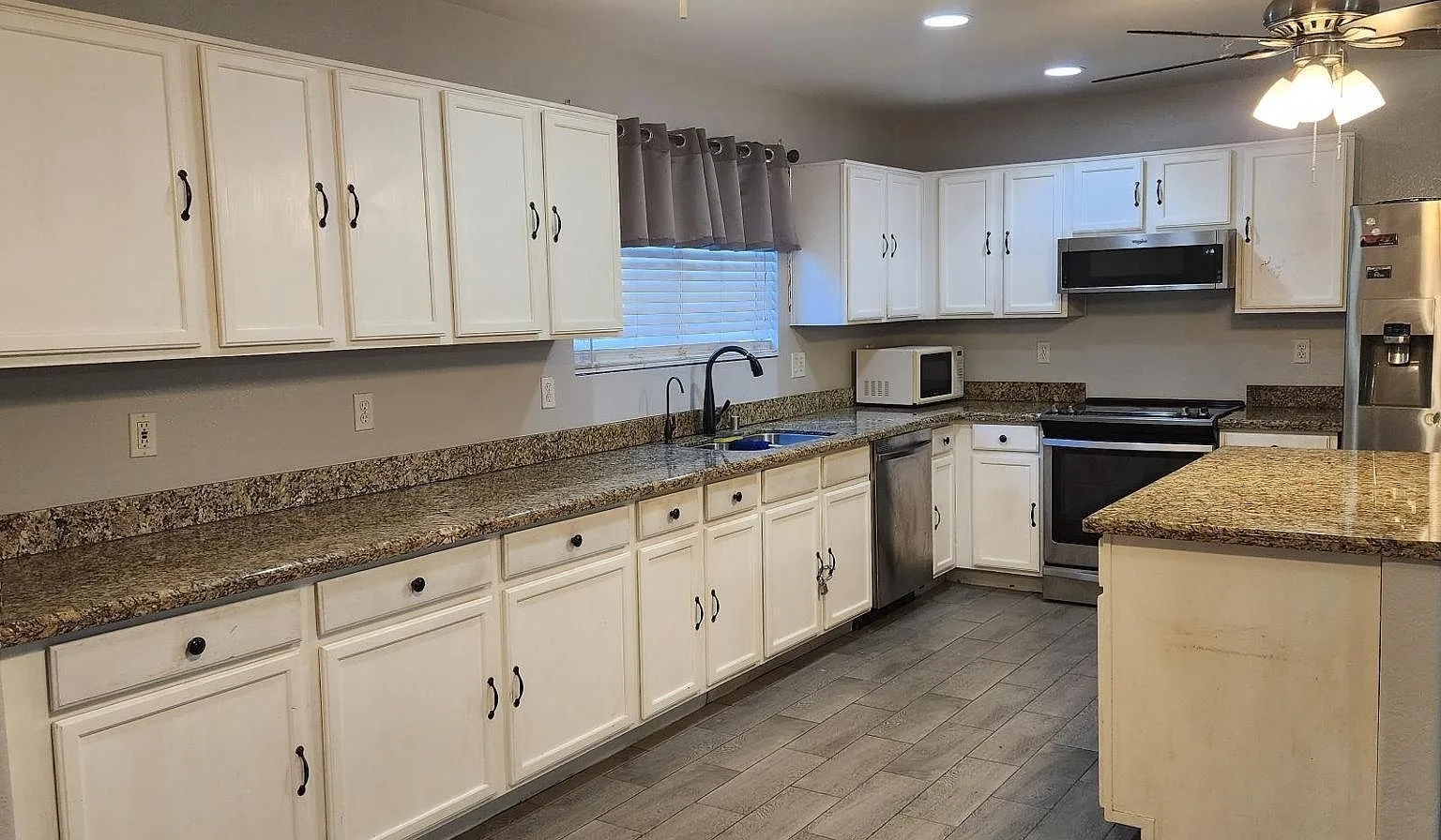 White shaker kitchen with granite counters and a center island
