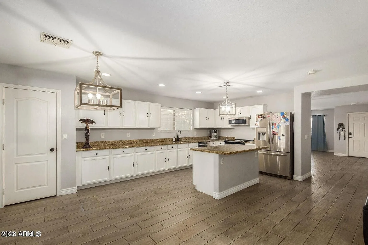 White kitchen with granite countertop and stainless appliances