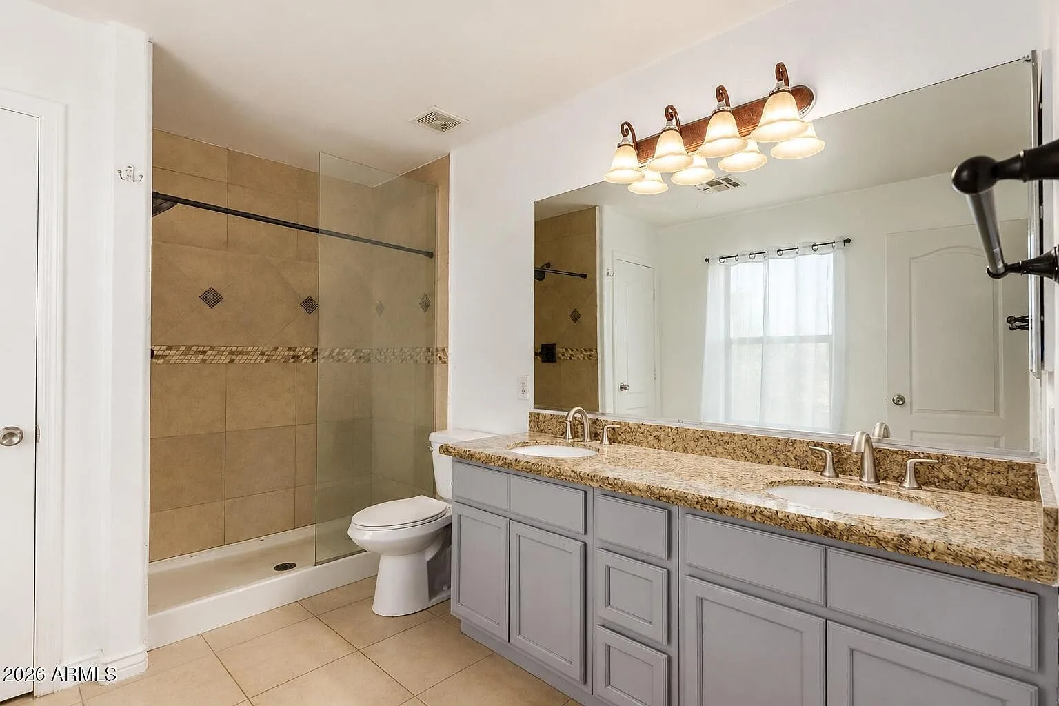 Bathroom with granite double vanity and tiled walk-in shower
