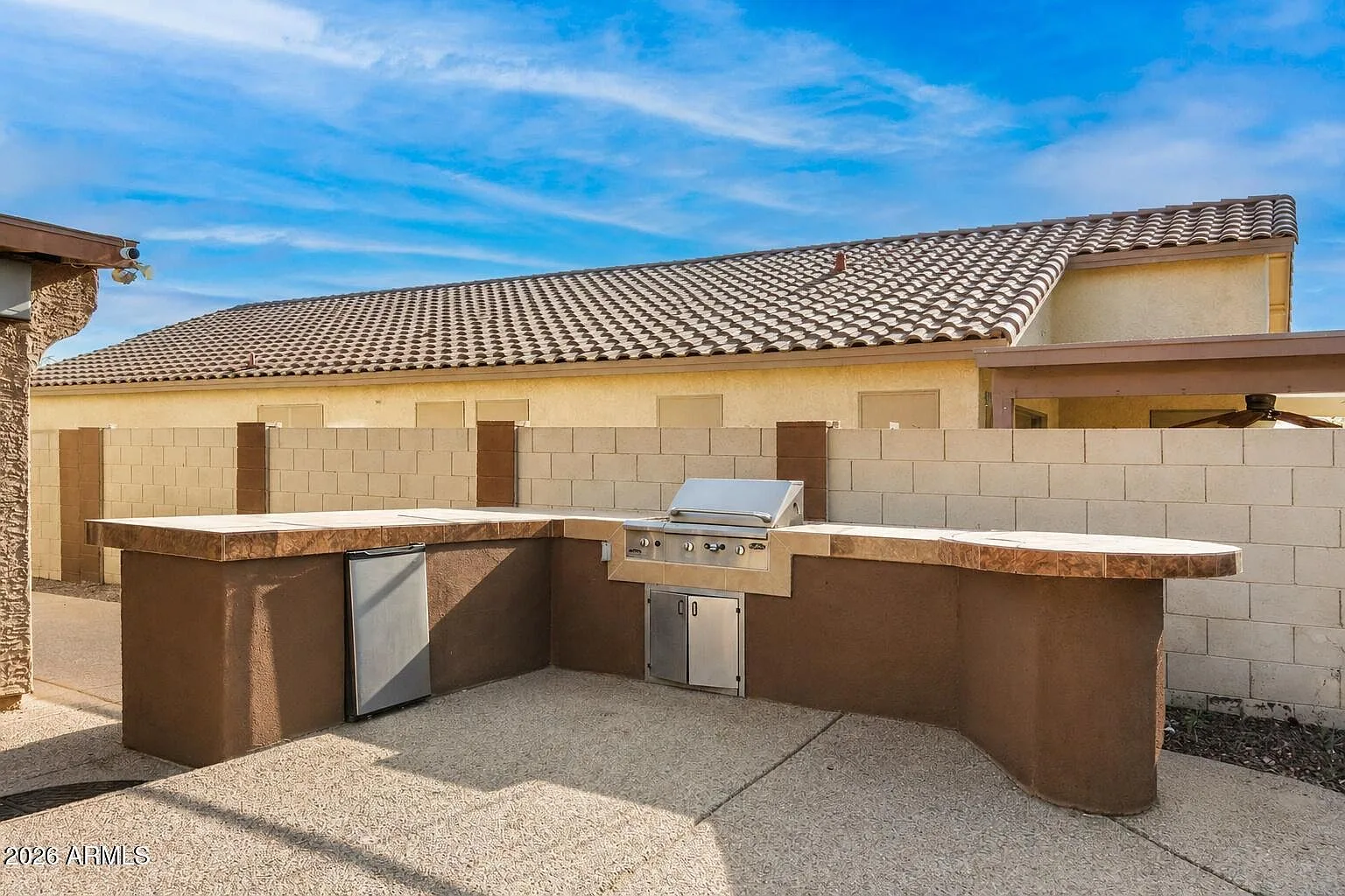 Built-in outdoor kitchen with grill and stone countertop