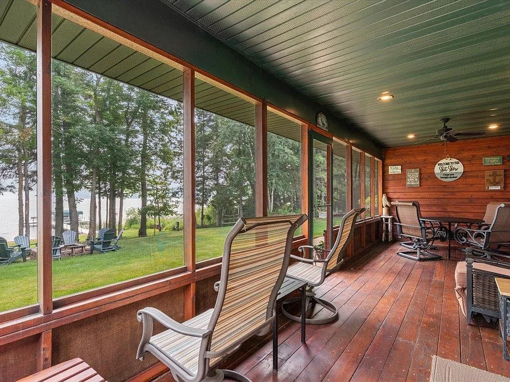 Lakeside screened porch with wood walls and a painted ceiling, looking toward the lake