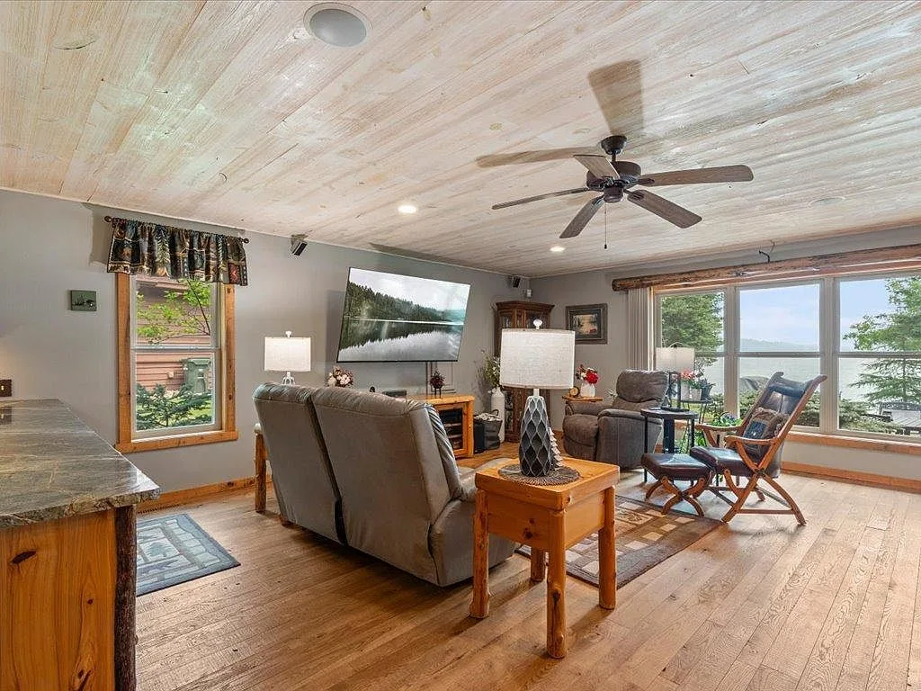 Lakeside living room with planked ceiling and large windows