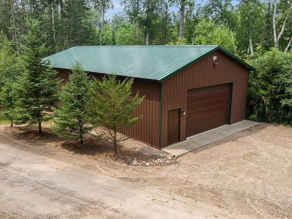 Exterior of the detached shop with brown metal siding and a large roll-up door