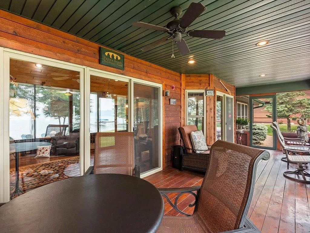 Screened porch seating area with lake views and wood paneling