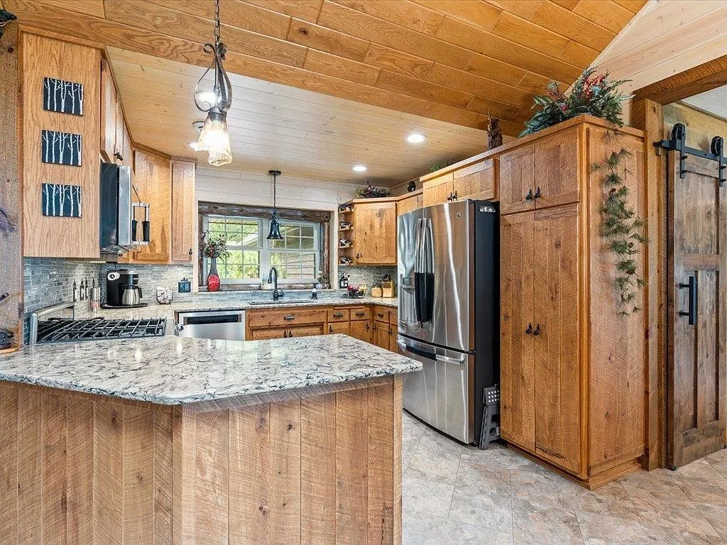 Kitchen at 16138 Zigmund Dr with light wood cabinetry, quartz countertops, and a vaulted wood ceiling