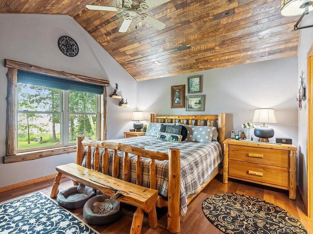 Master bedroom with vaulted wood ceiling and log-frame bed