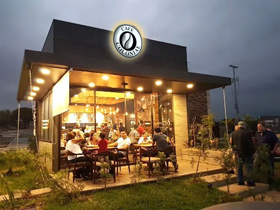 The coffee shop flagship: a modern cafe facade with stone veneer accents, glass walls and warm evening lighting
