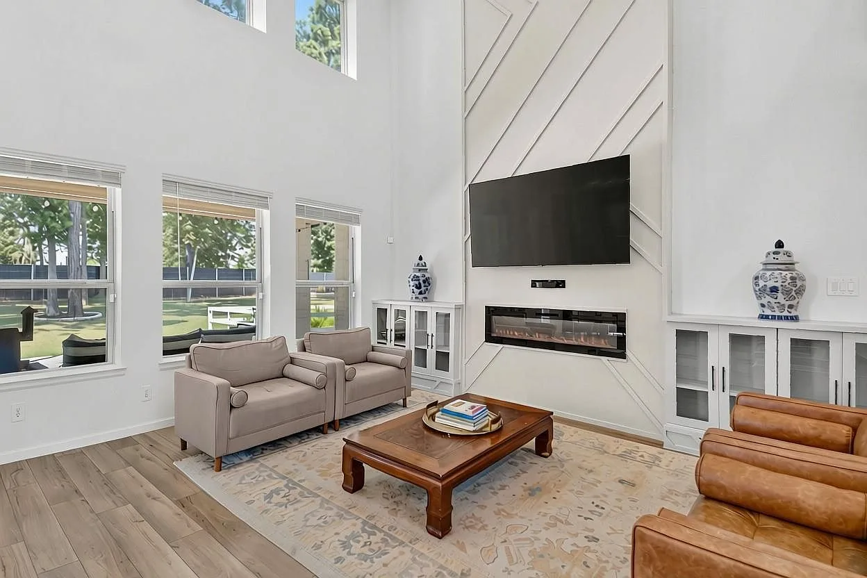 Floor-to-ceiling fireplace with built-in cabinetry beneath an 18-foot ceiling