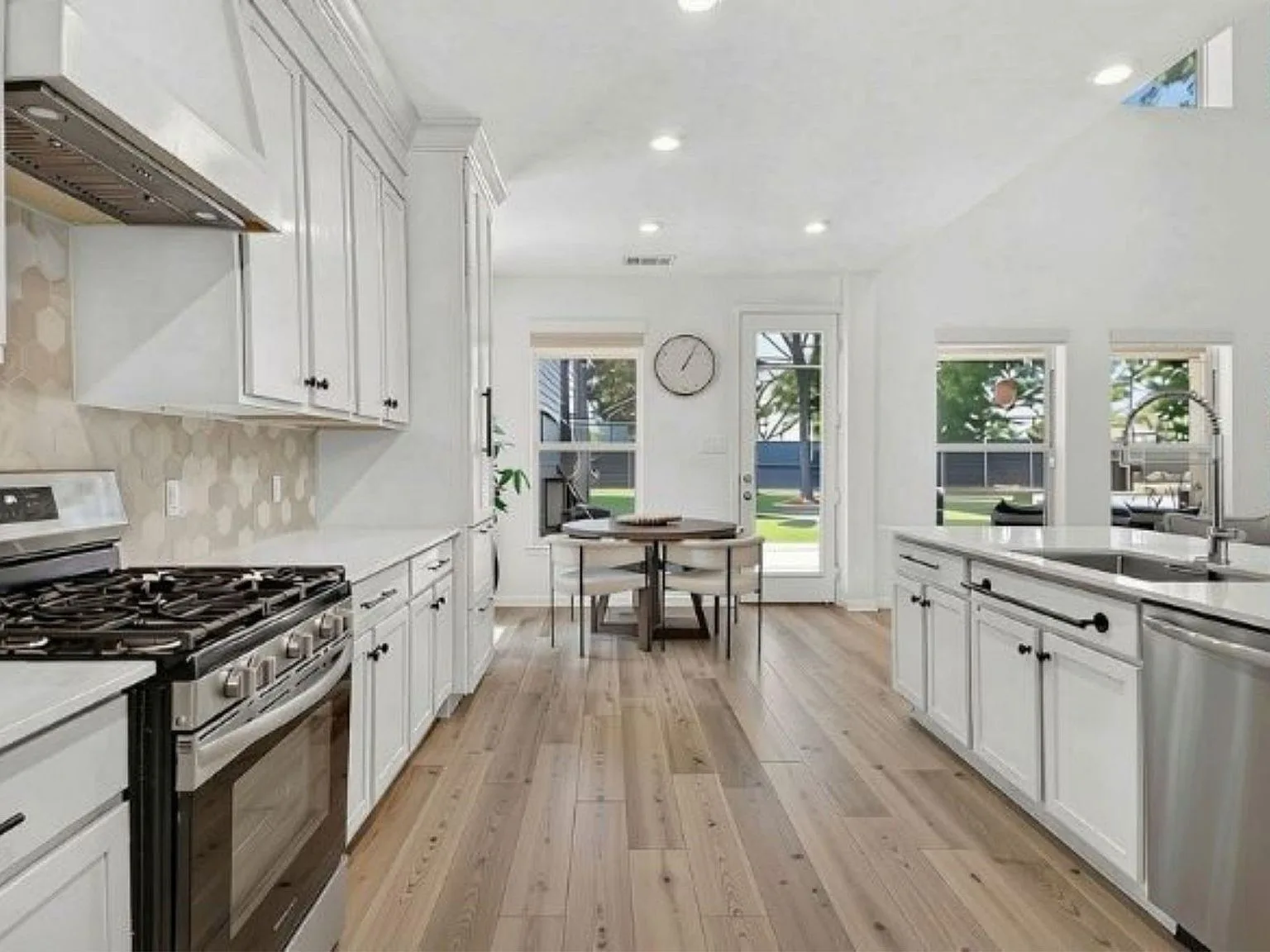 Kitchen with tall custom cabinetry, quartz counters, and a view to the dining area and backyard