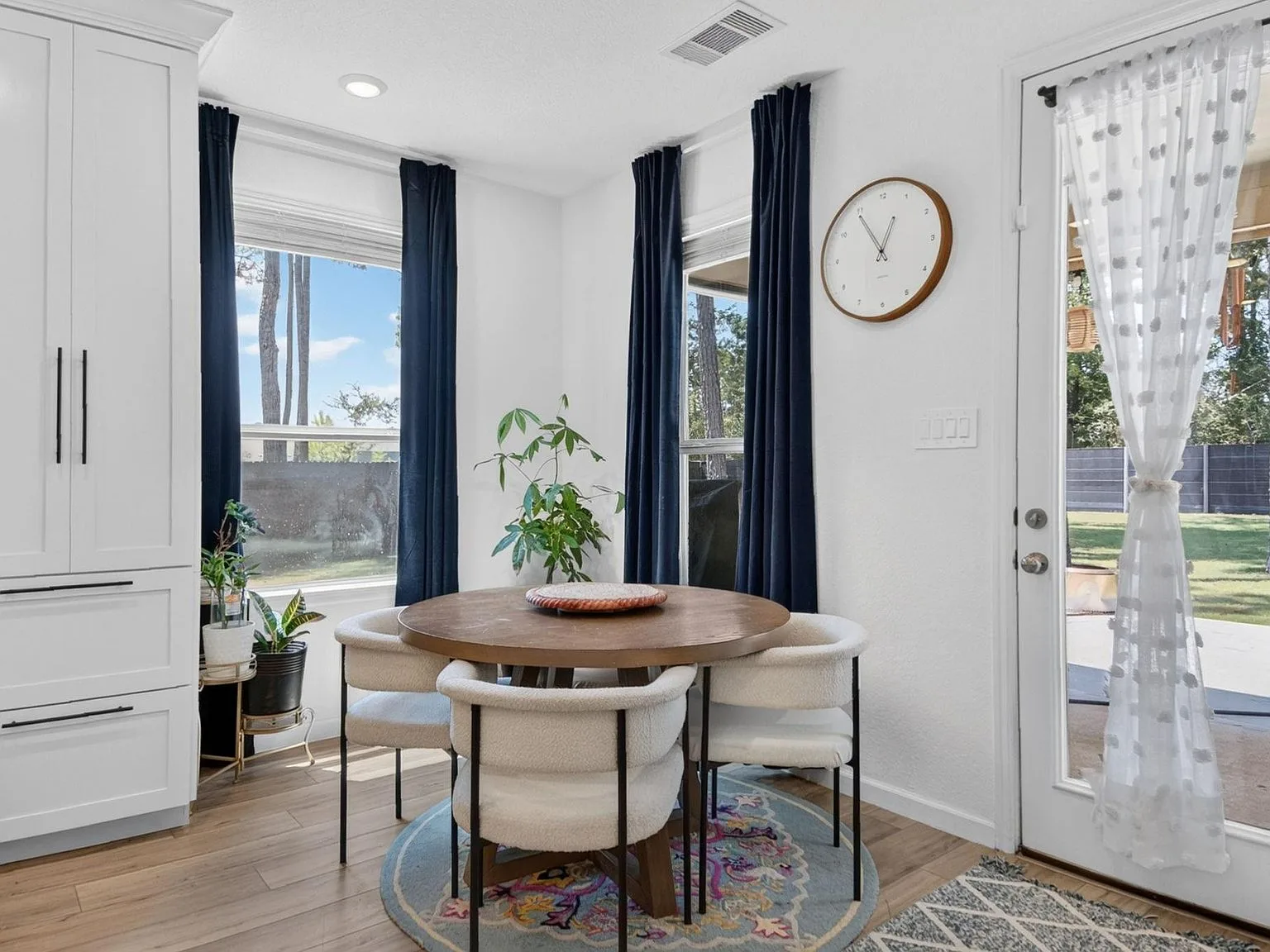 Breakfast dining area with custom cabinets and large windows with navy curtains