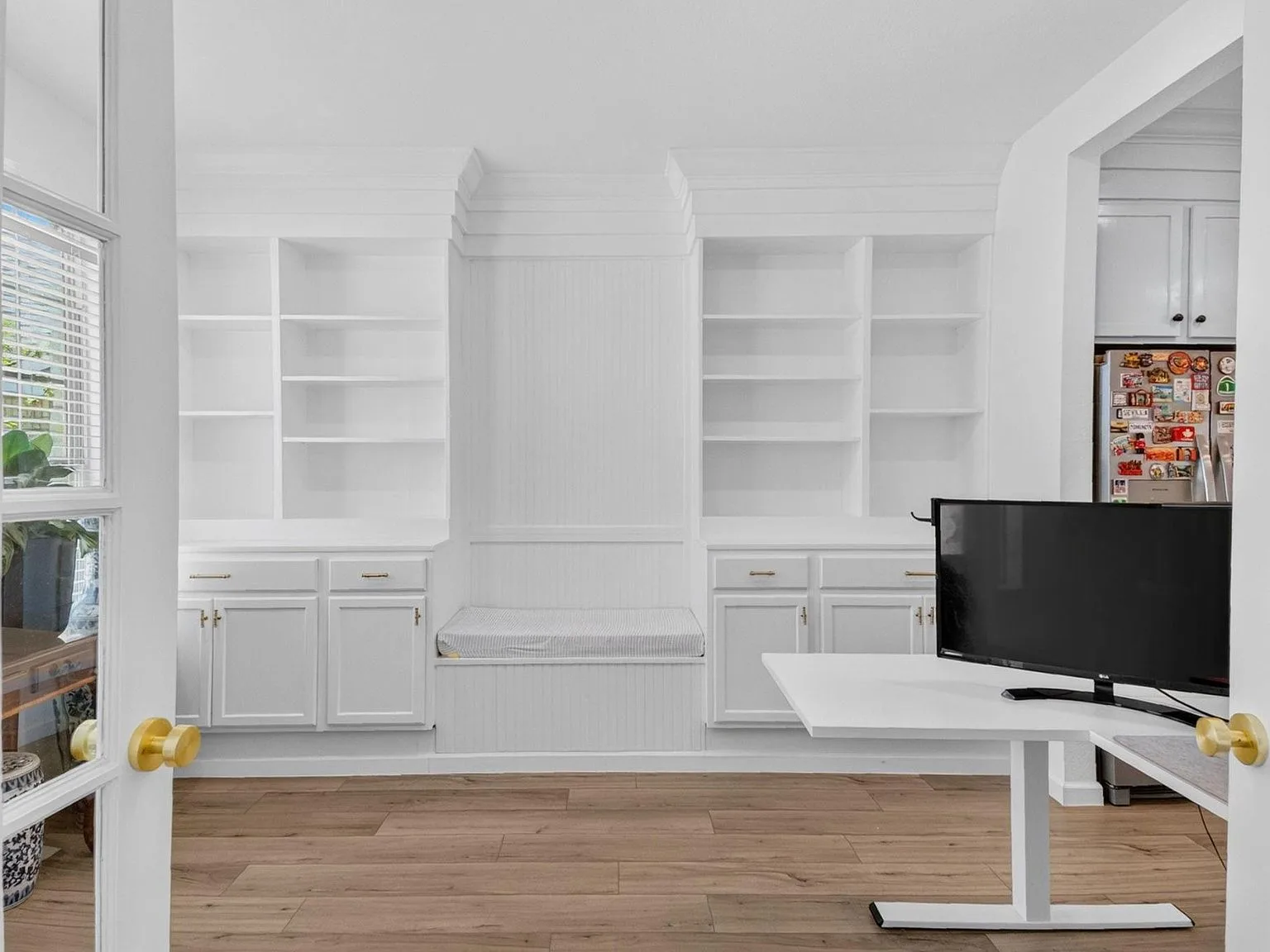 Home office study with built-in shelving behind double French doors