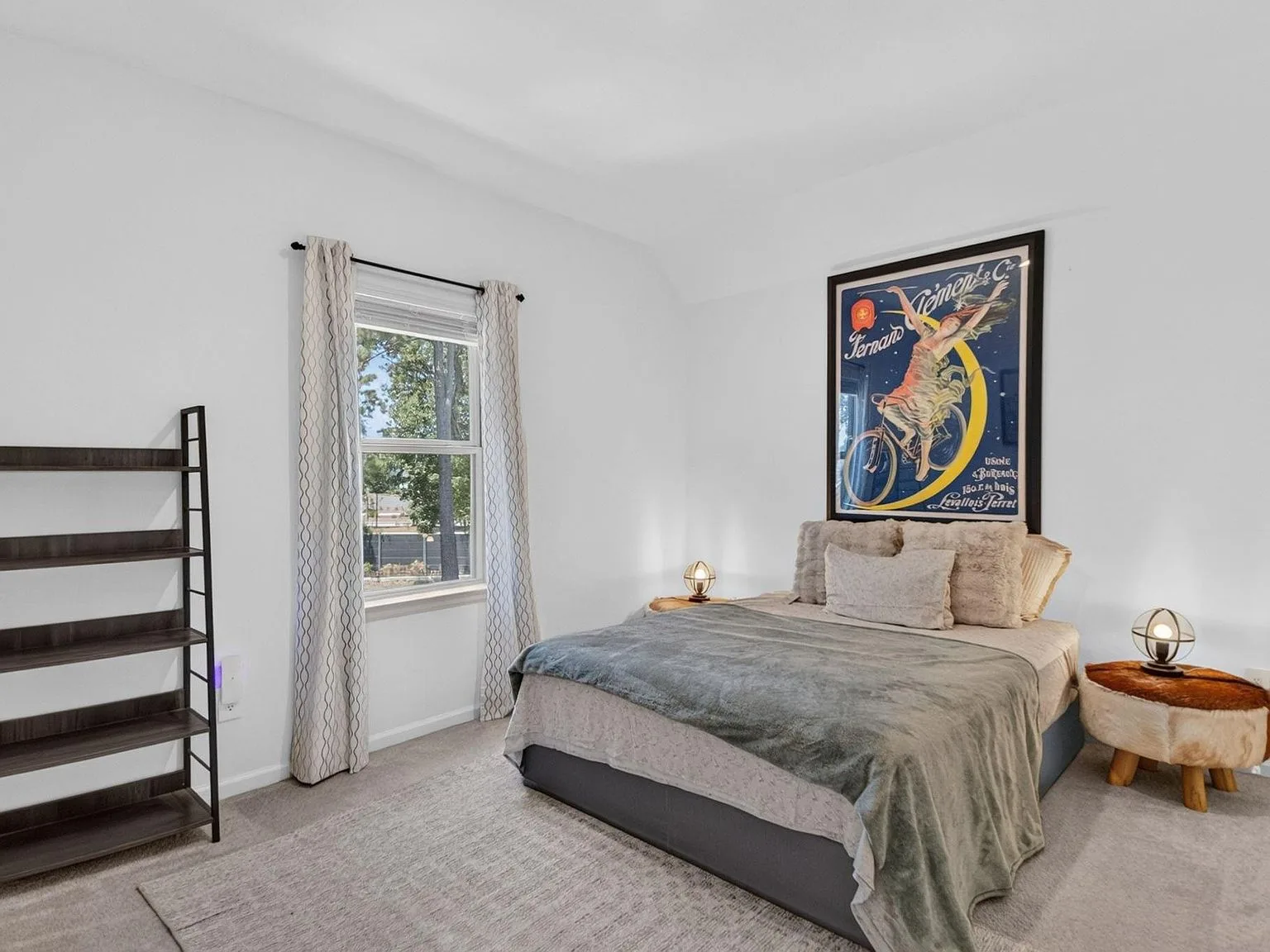 Spacious guest bedroom with neutral walls, natural daylight, and carpet