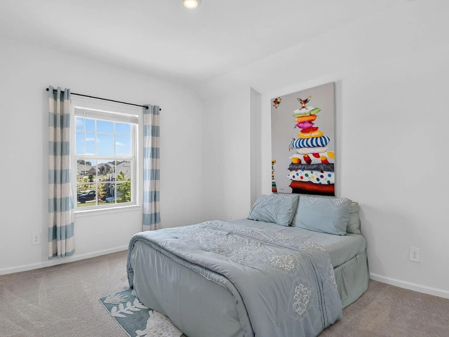 Secondary bedroom with neutral finishes and a single window letting in daylight