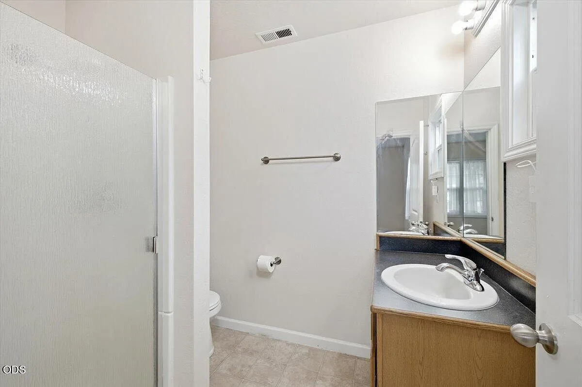 Primary bathroom with a shower stall, vanity, and large mirror