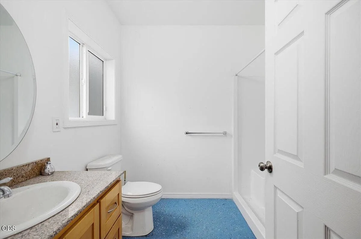 Bathroom with a light wood vanity, laminate countertop, and window light