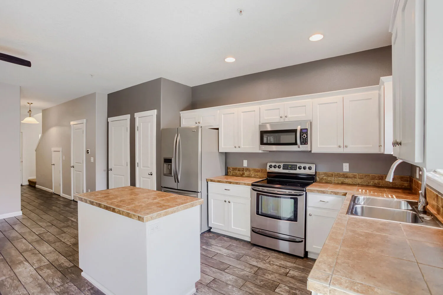 Kitchen with white cabinetry and island at the townhome at 14980 SW Conor Cir, Beaverton, OR