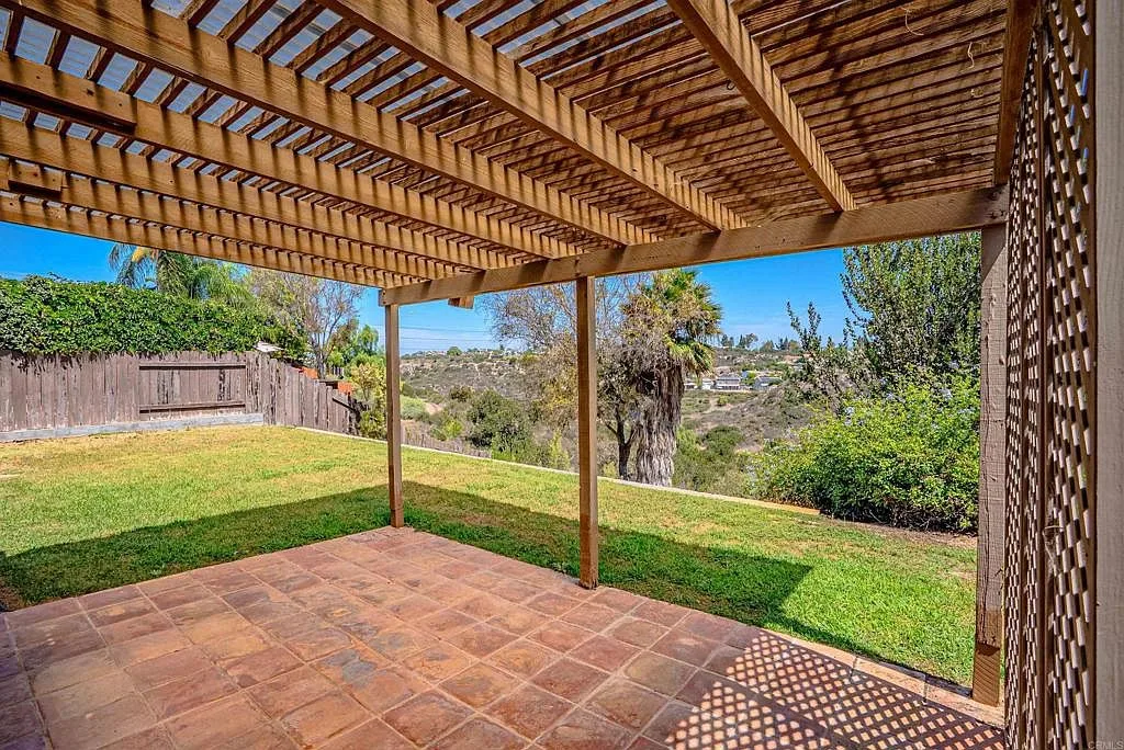 Covered backyard patio with pergola and tile flooring