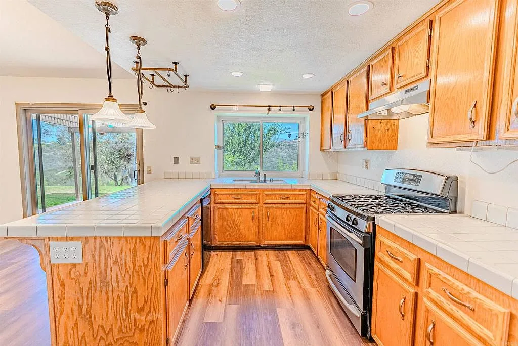 Kitchen with wood cabinetry looking toward the sliding glass door