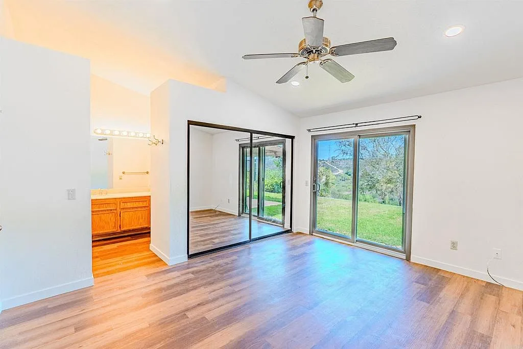 Primary bedroom with sliding glass door and mirrored closet doors