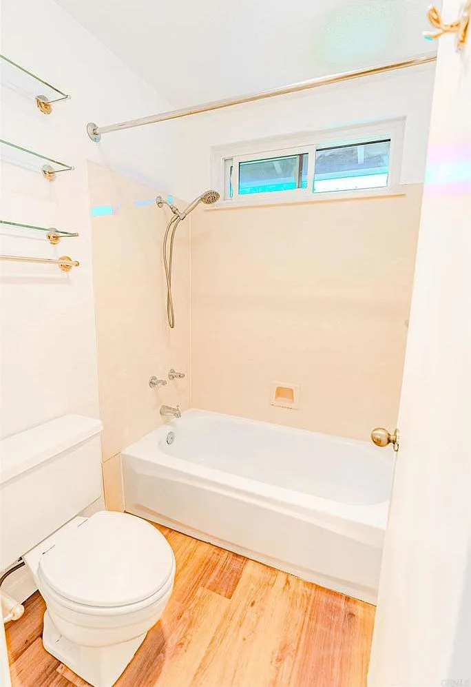 Renovated bathroom with tub and beige tile surround
