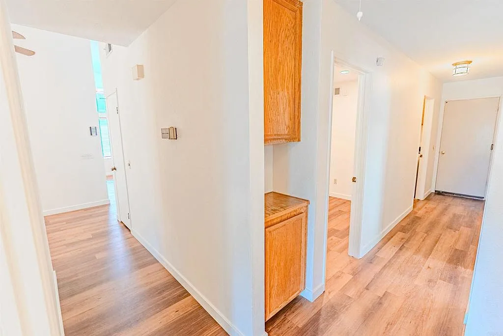Interior hallway with wide plank flooring and built-in cabinet