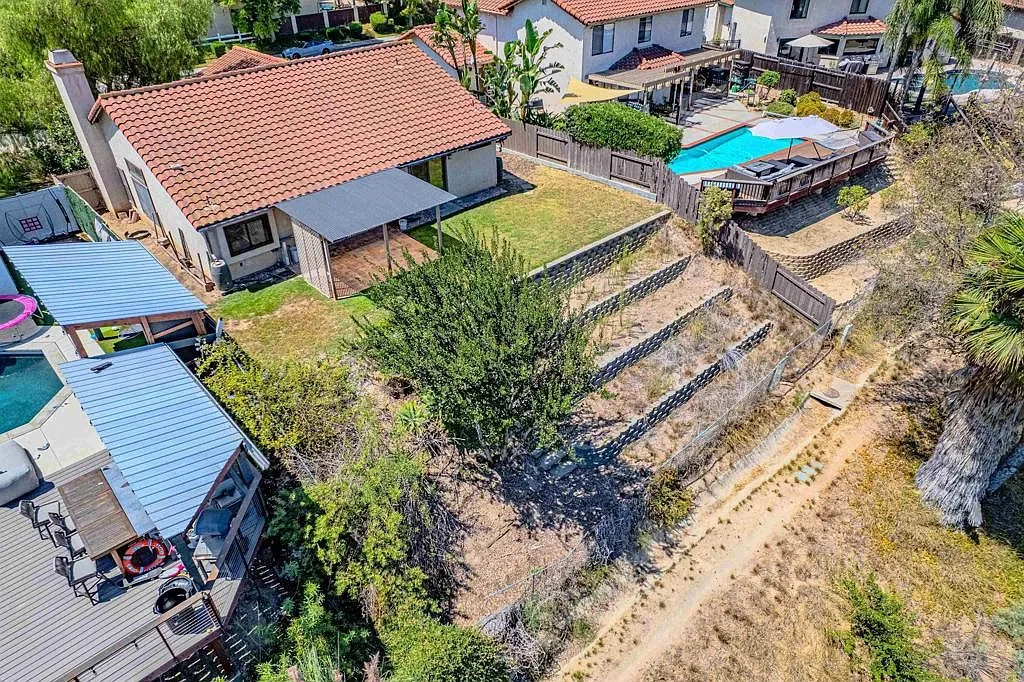 Aerial of the terraced backyard and covered rear patio