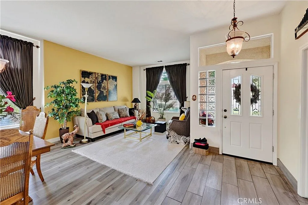 Open-concept living and dining area near the entry of 1755 E Tuolumne Rd with wood-look plank flooring and an accent wall