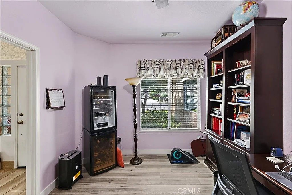 Dedicated home office at 1755 E Tuolumne Rd with built-in shelving, a desk and warm wood-look flooring