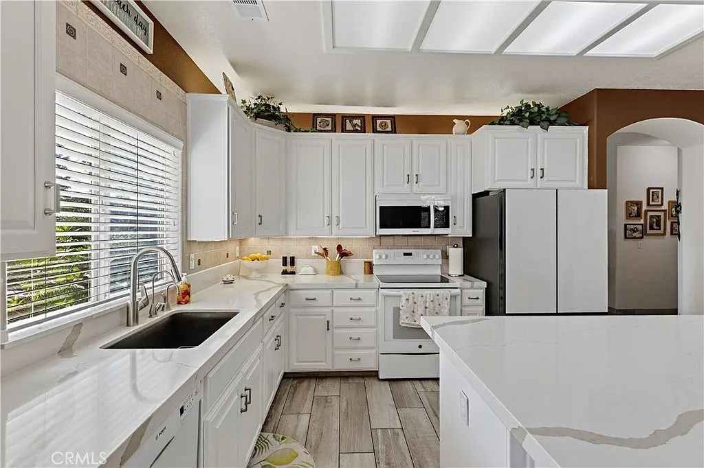 Updated kitchen at 1755 E Tuolumne Rd with white cabinetry, light countertops and recessed panel ceiling lights