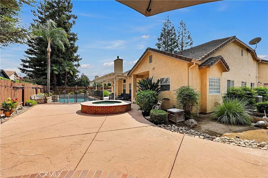 Backyard pool and circular brick spa at 1755 E Tuolumne Rd beside the covered patio