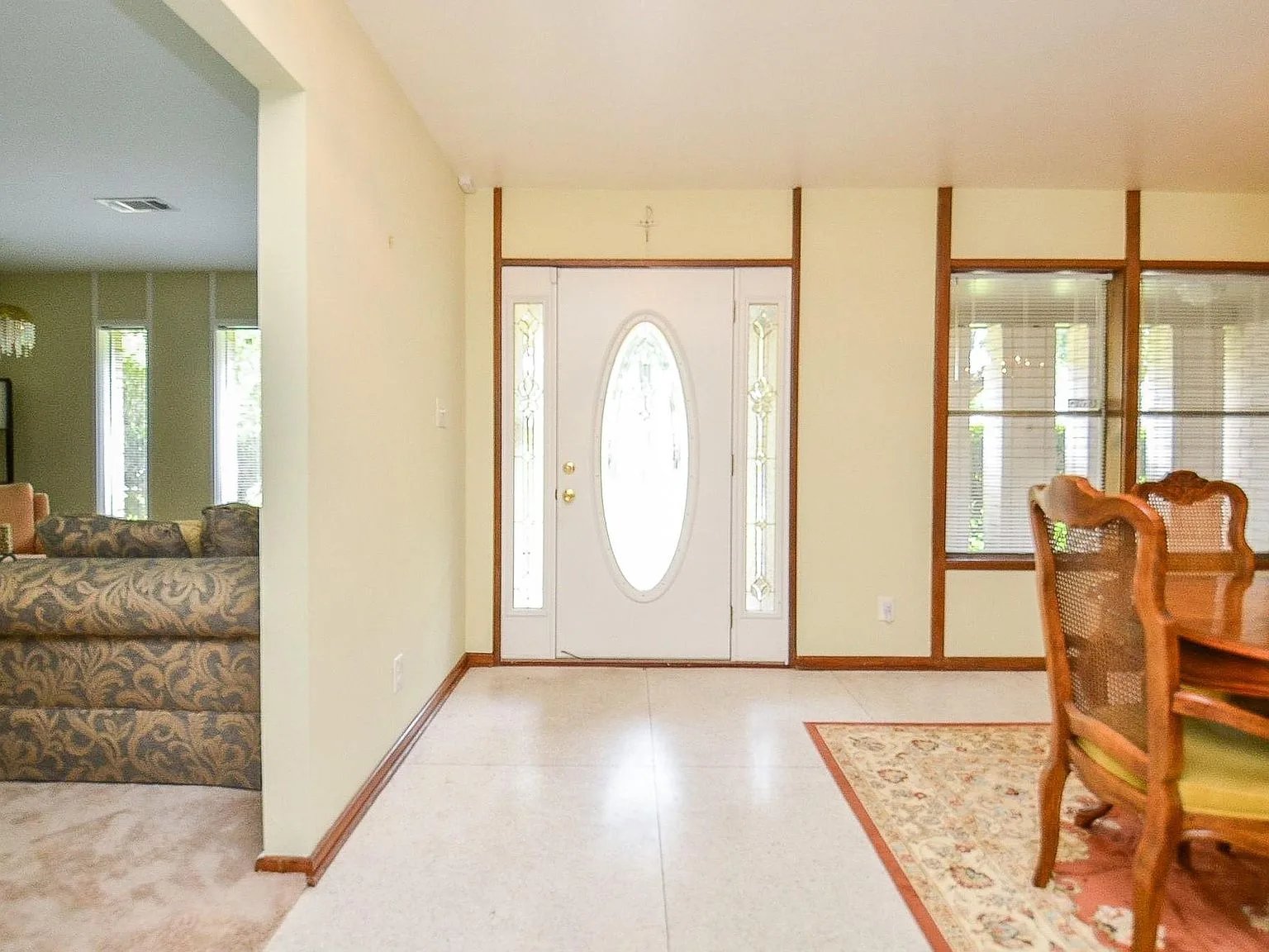 Foyer entryway at 6203 Wigton Dr with wood trim and a front door featuring an oval glass insert