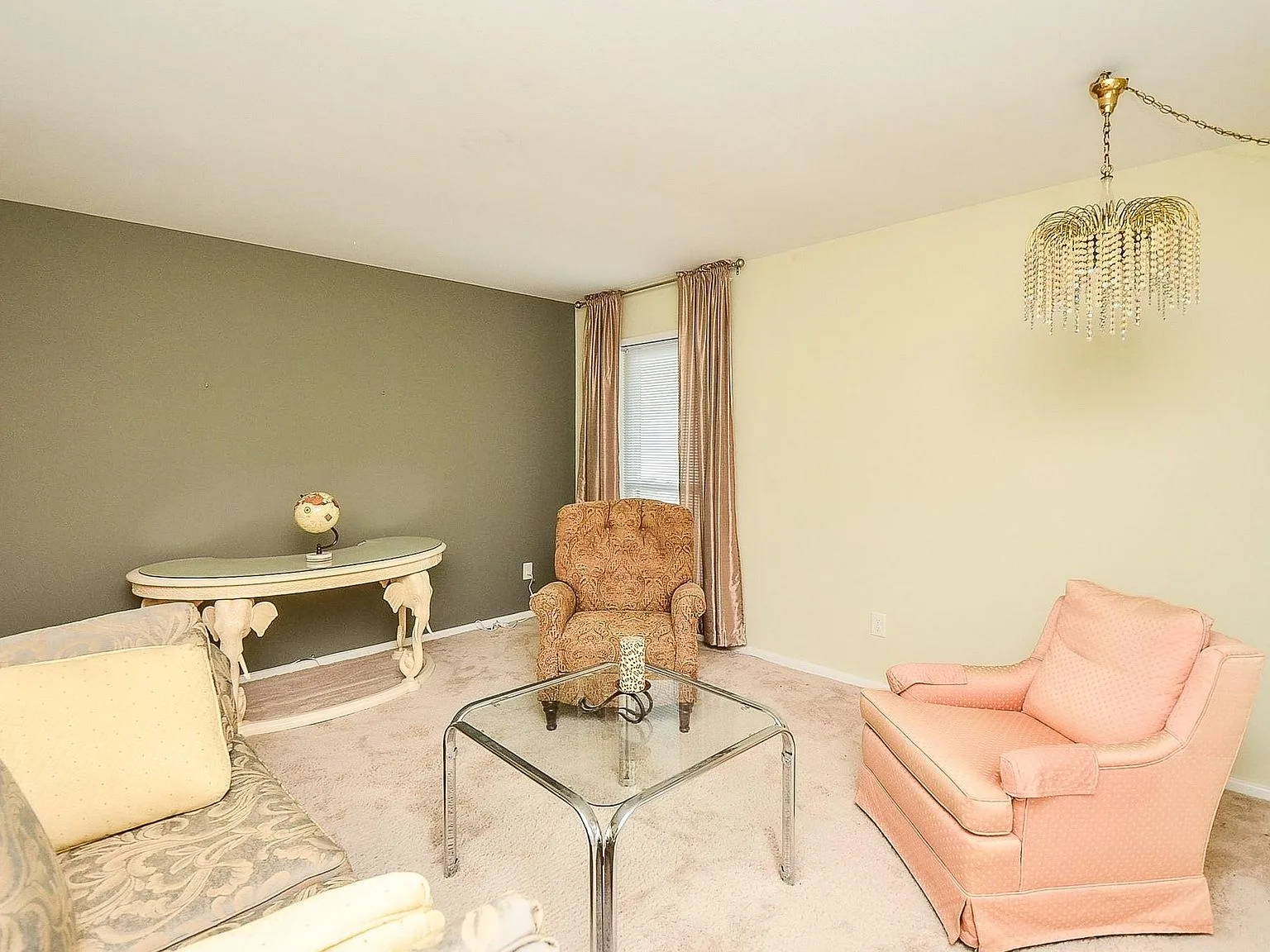 Living room with an olive green accent wall and mid-century furniture
