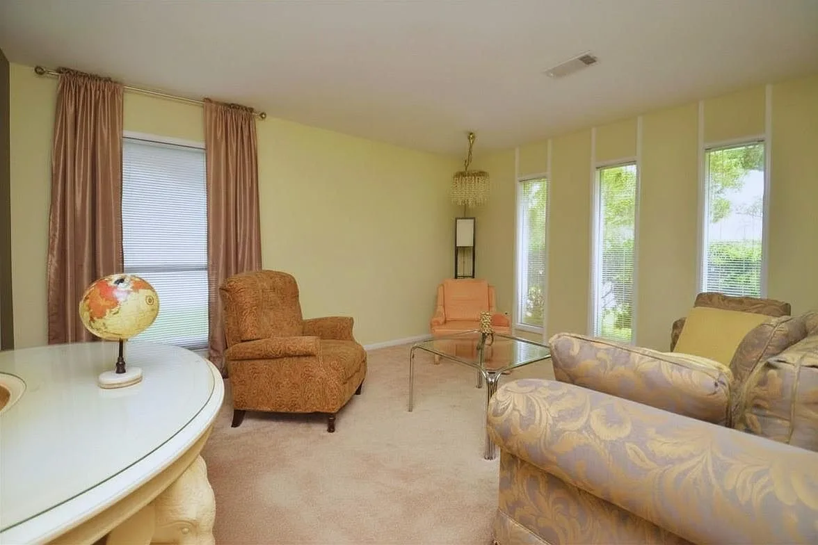 Spacious living room featuring original mid-century wall paneling and natural light