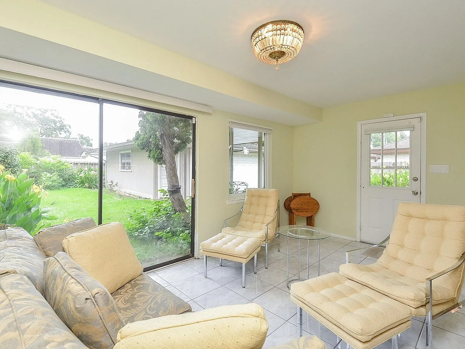 Sunroom living area with tile floors and large sliding glass doors
