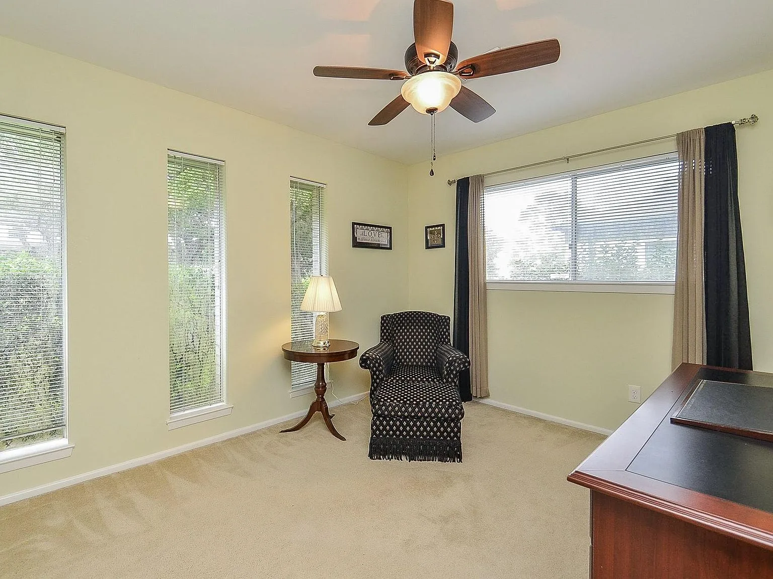 Bedroom used as a home office with beige carpet and natural daylight