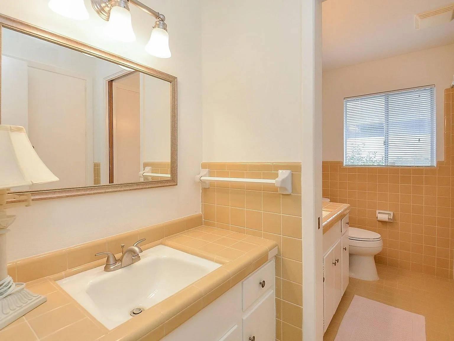 Bathroom with original yellow ceramic tile countertop and backsplash