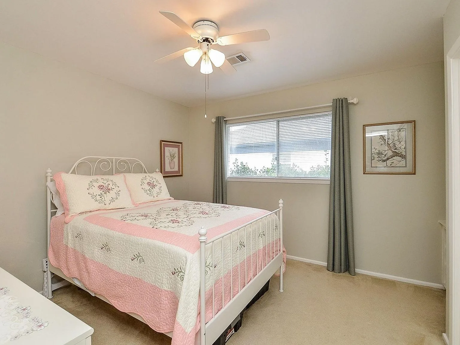 Secondary bedroom with neutral beige walls and carpet