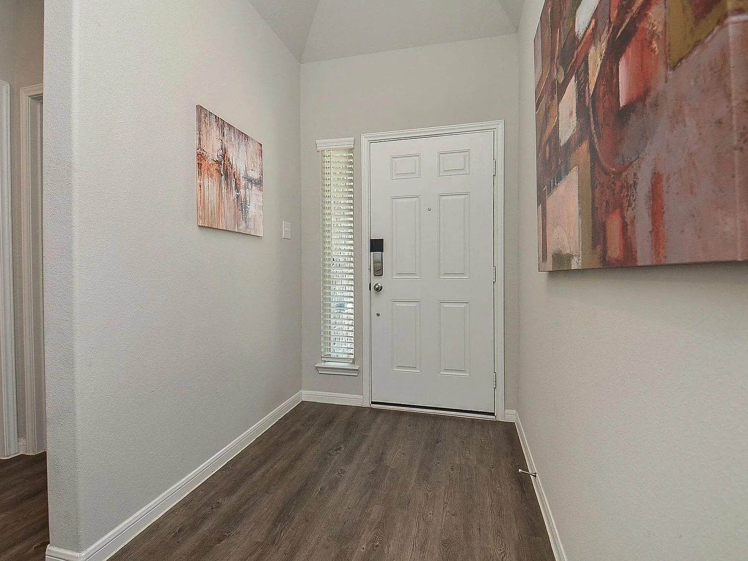 Entry foyer with wood-look flooring and neutral walls