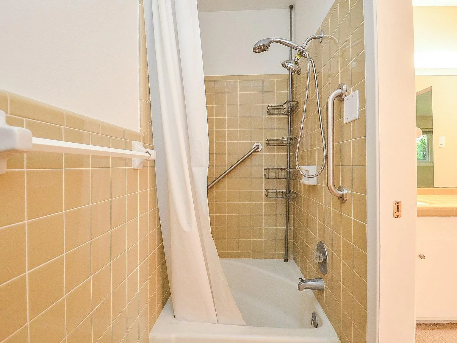 Bathroom tub and shower combination with original mustard-colored tile