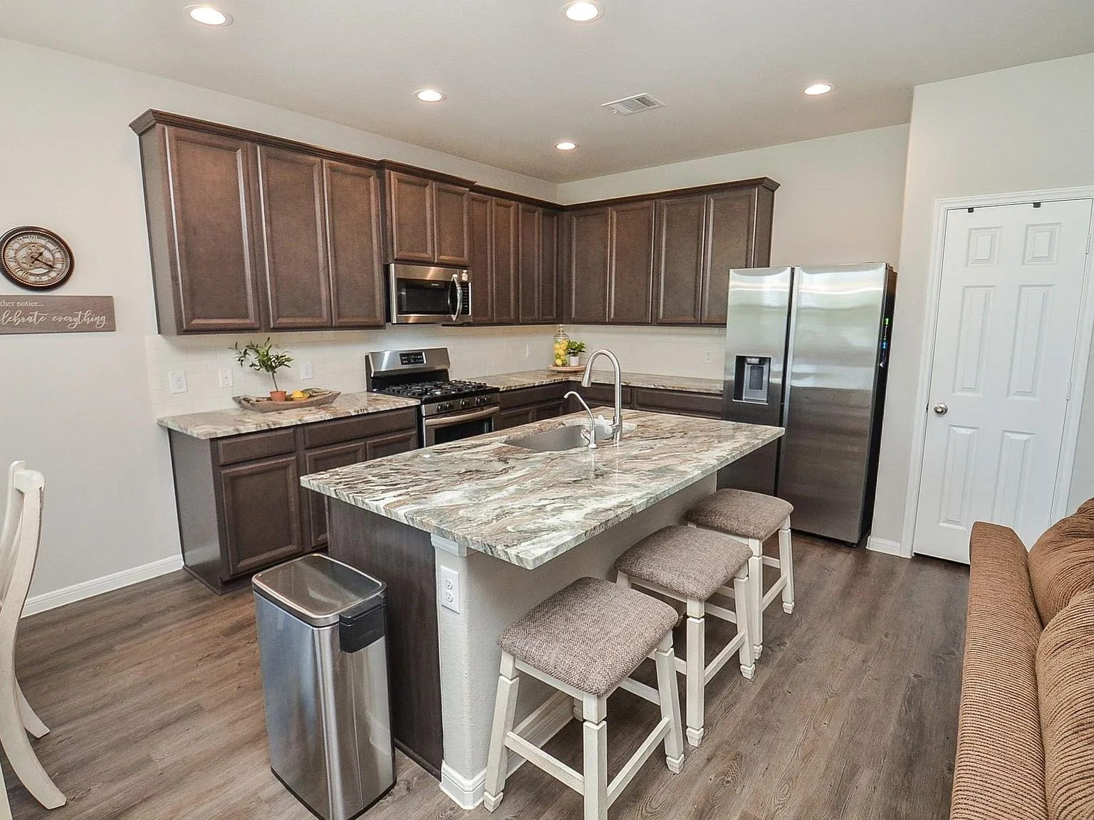 Kitchen island with dark wood cabinetry and granite counters