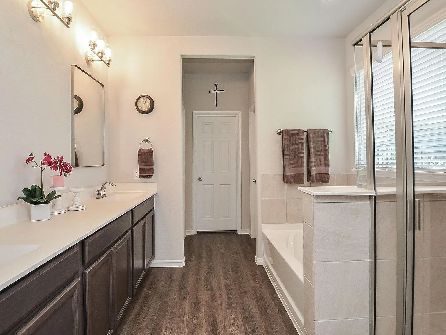 Primary bathroom with dual vanities and a glass-enclosed shower