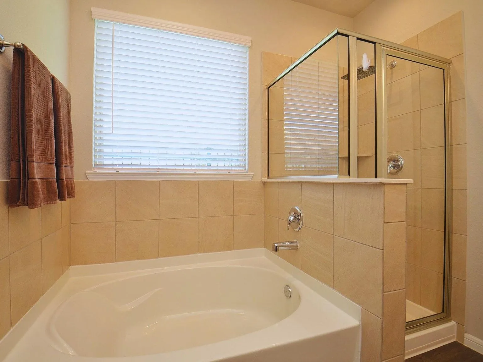 White soaking tub beside a glass-enclosed shower
