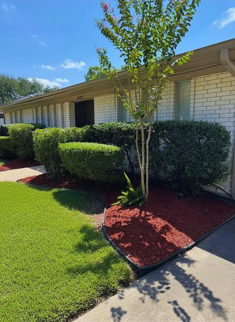 Angled view of the home with brick exterior and trimmed hedges