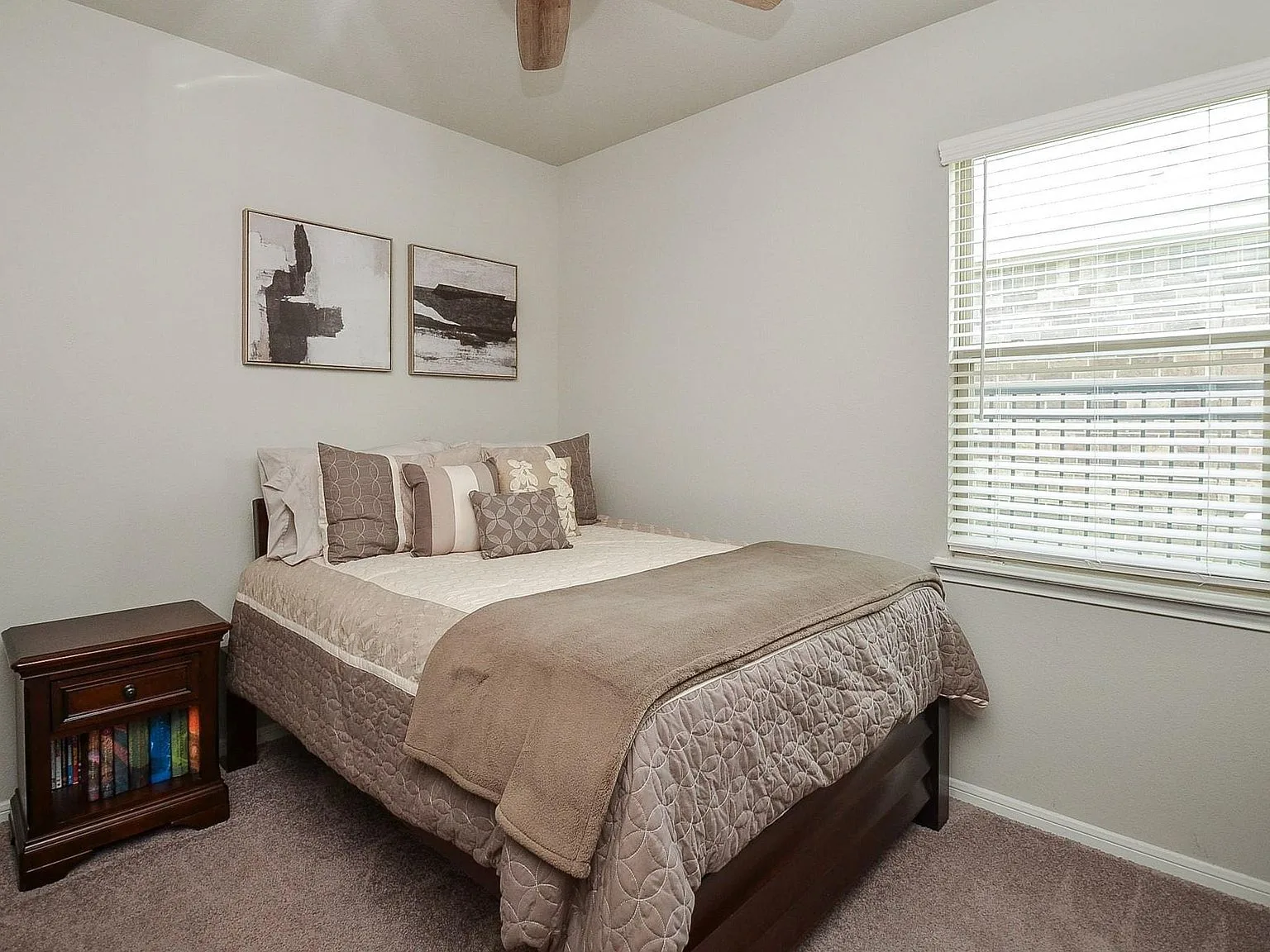 Guest bedroom with neutral carpet and window light