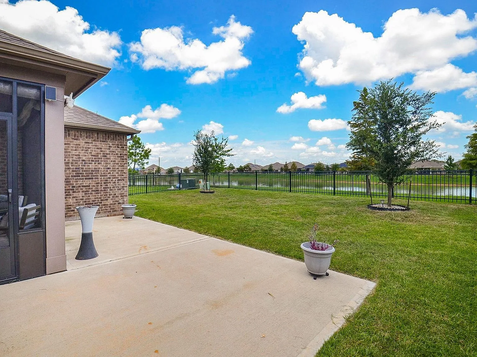 Screened patio and black metal fence looking out over the lake