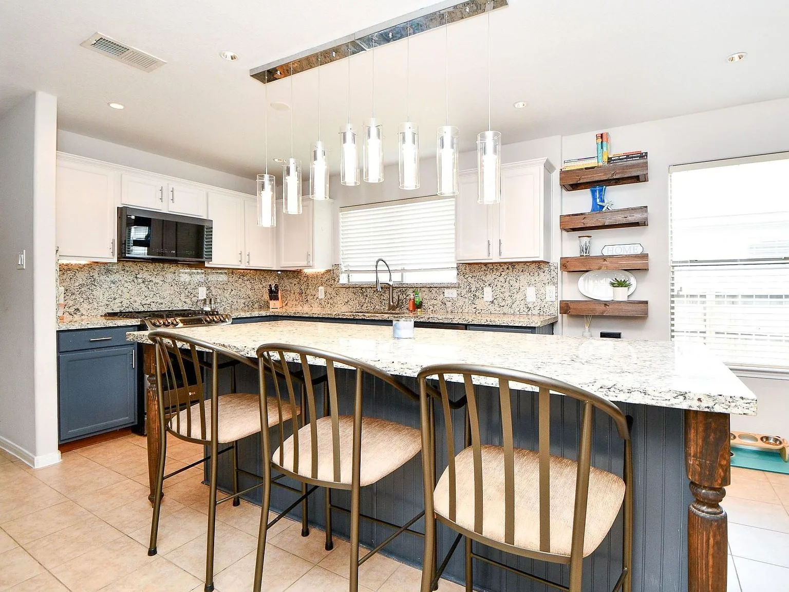 Kitchen island with granite countertops and two-tone cabinets