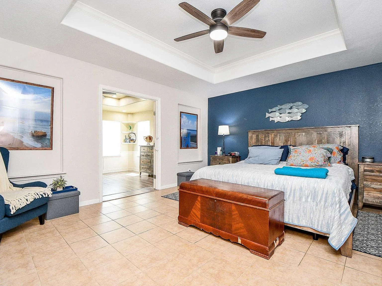 Primary bedroom with tray ceiling and accent wall