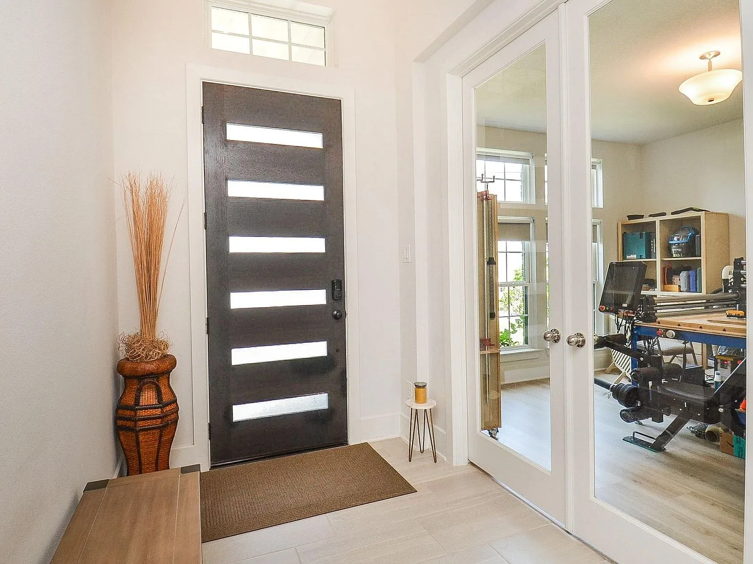 Entry foyer with French doors opening to an office flex space