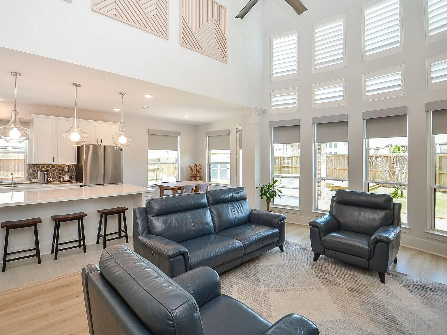Open-concept living room and kitchen with vinyl plank flooring and high ceilings